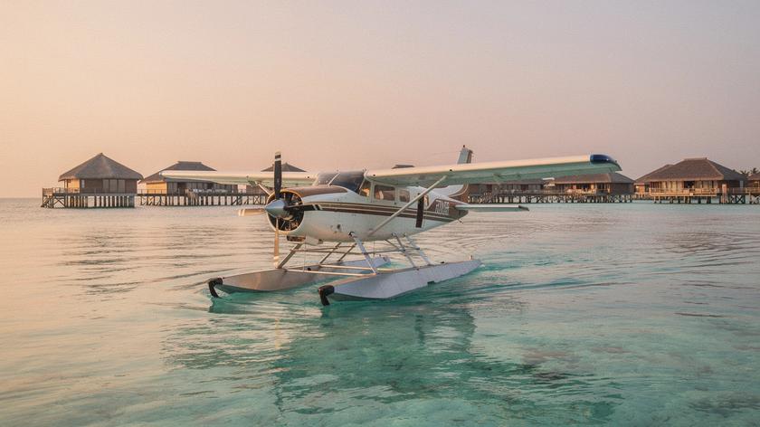 Seaplane resting on a Maldives lagoon at sunrise