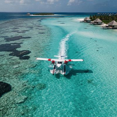Seaplane taxiing on turquoise Maldives lagoon
